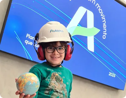 Profissional da Automa com capacete e uniforme de segurança diante de uma usina solar